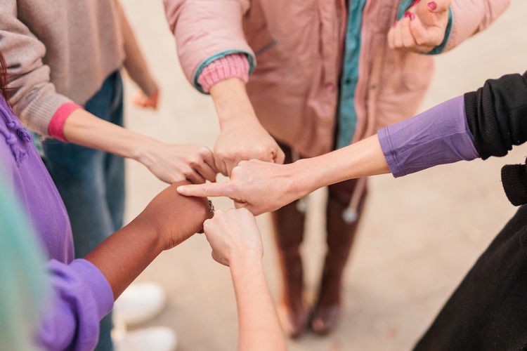 Midsection of people stacking hands