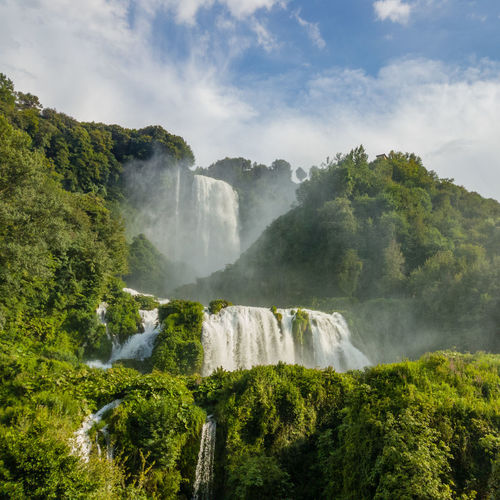 Scenic view of waterfall against sky