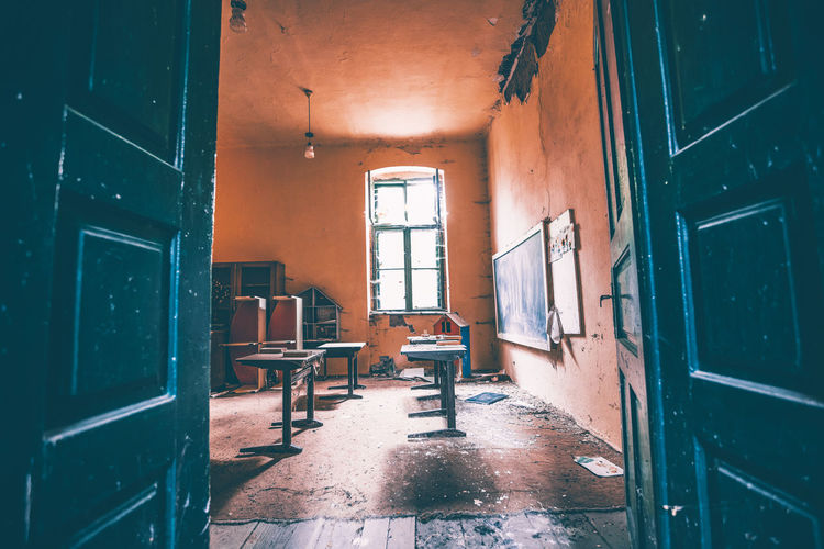 Empty chairs and table in abandoned building
