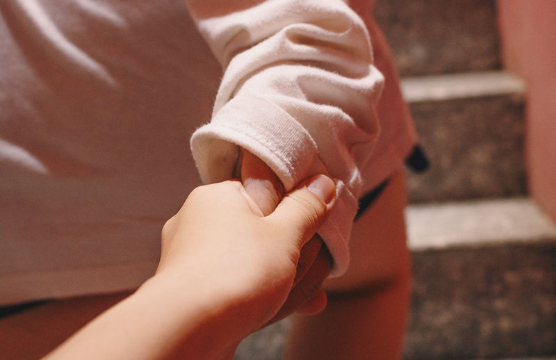 Close-up of mother holding hands of baby at home