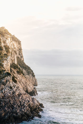 Scenic view of rock formation in sea against sky