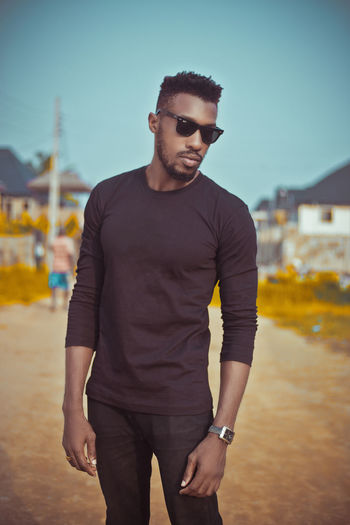 Man wearing sunglasses while standing against sky