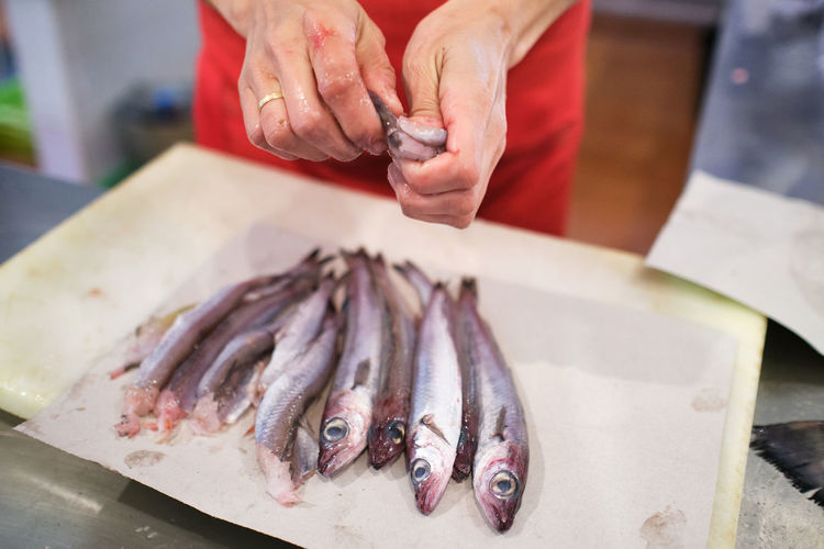 Young woman's hand teaches shrimp in the fish shop to her customers
