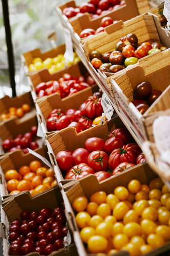 Various tomatoes for sale in shop with organic food