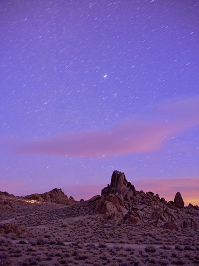 Campers on a ridge, star trails in the sky, alabama hills.