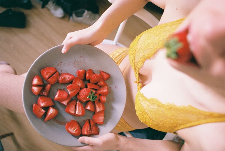 Sensuous woman holding plate with strawberries at home