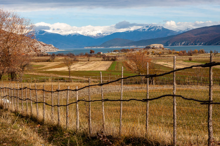 Scenic view of field by mountains against sky
