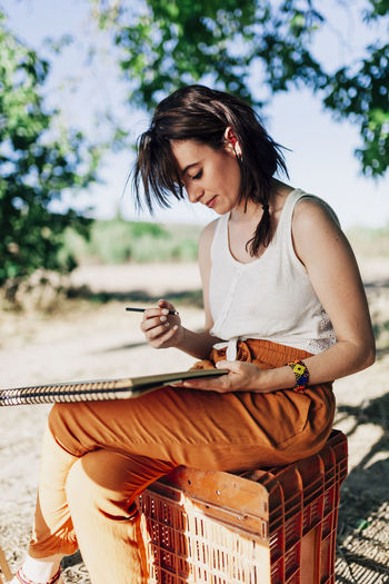 Young woman artist drawing in spiral notebook