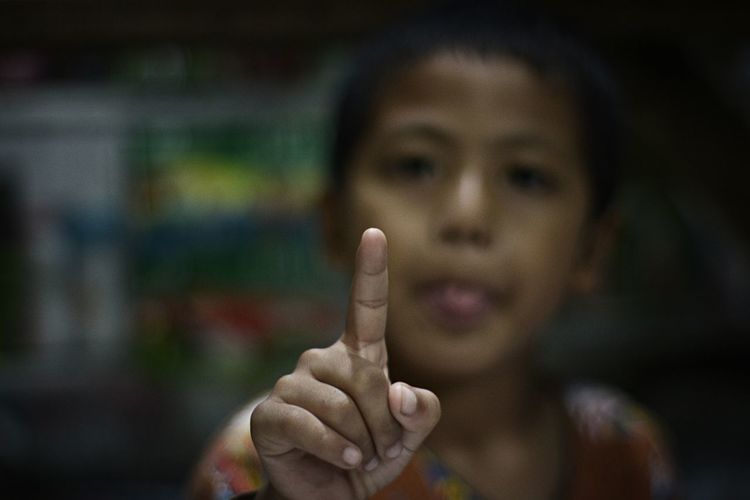 Close-up of boy pointing at camera