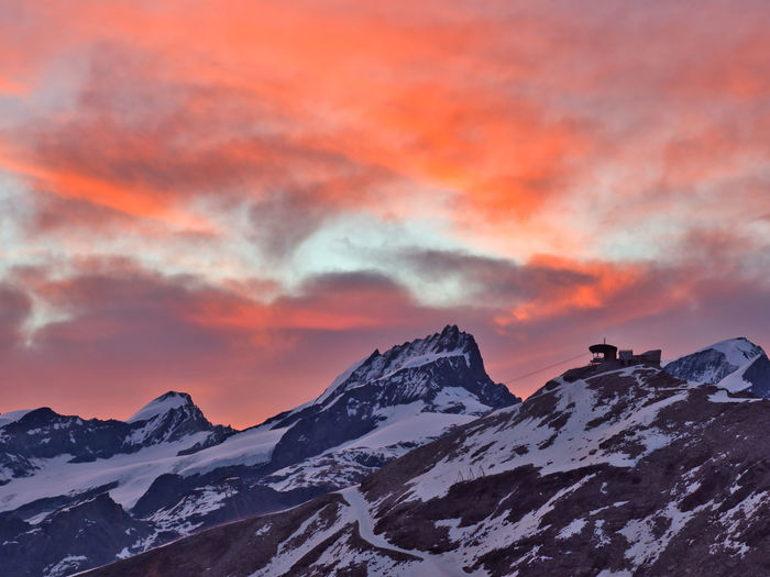 Scenic view of snowcapped mountains against sky during sunrise 