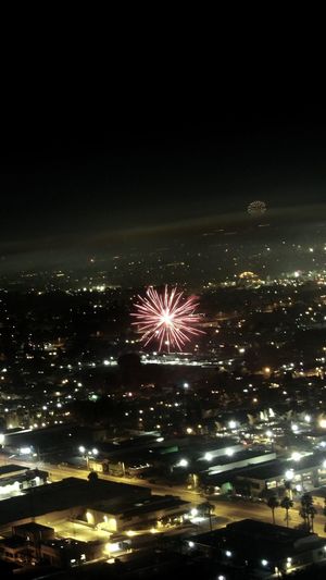 Firework display over illuminated buildings in city at night