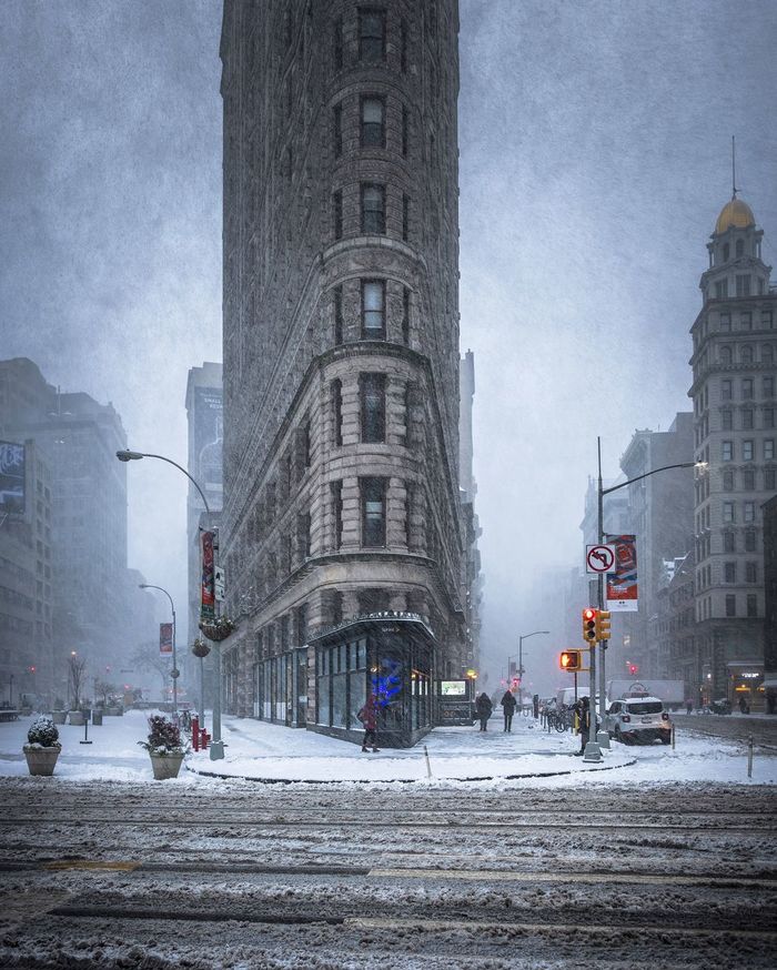 Flatiron building amidst streets in city during winter