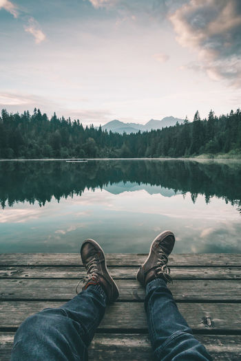 Low section of person relaxing on lakeshore