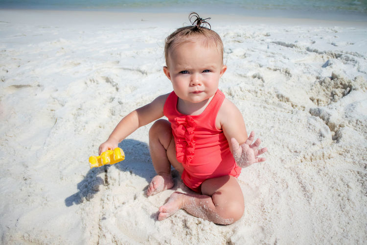 Baby girl playing on beach
