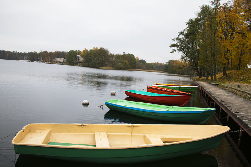 Old wooden boats near the beach of trakai gavle lake, lithuania. autumn and fall time.