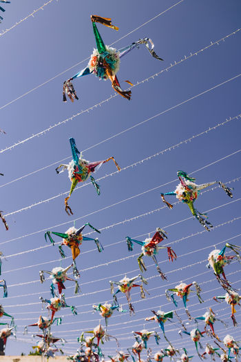 Low angle view of piñatas against clear sky for a celebration event