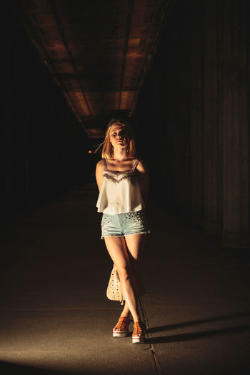 Portrait of young woman standing at parking garage