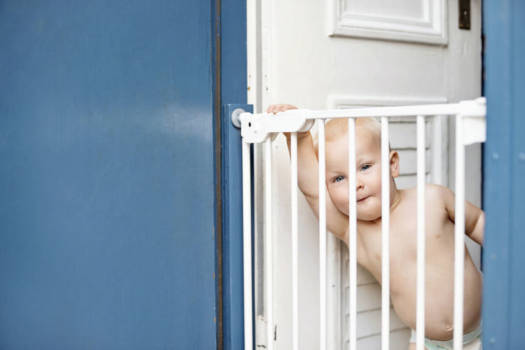 Baby boy looking through gate
