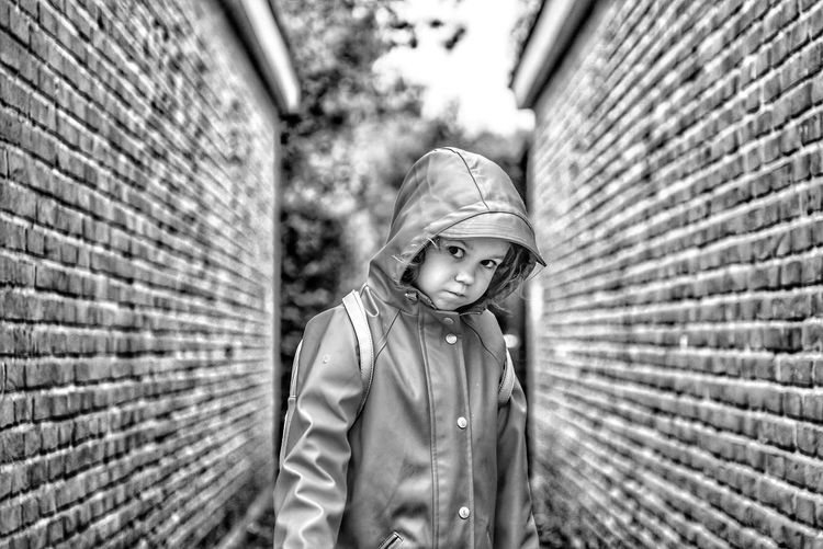 Portrait of boy standing against wall