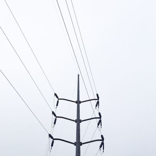 Low angle view of electricity pylon against clear sky