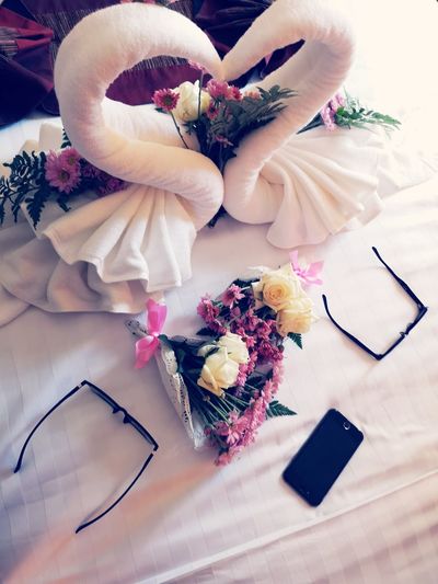 High angle view of towels and bouquets decorated on bed