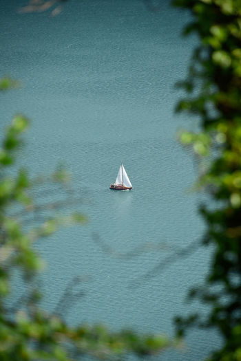 Sailboat in sea in turquoise mountain lake water 