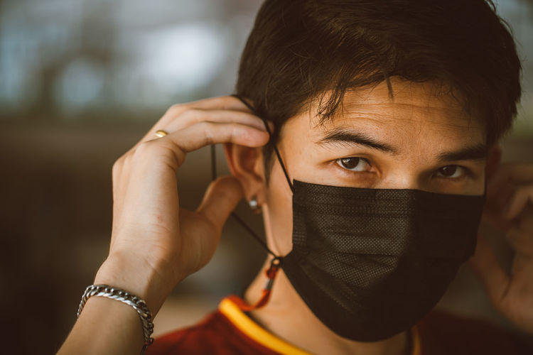 Young man wearing a black mask to protect against the virus.