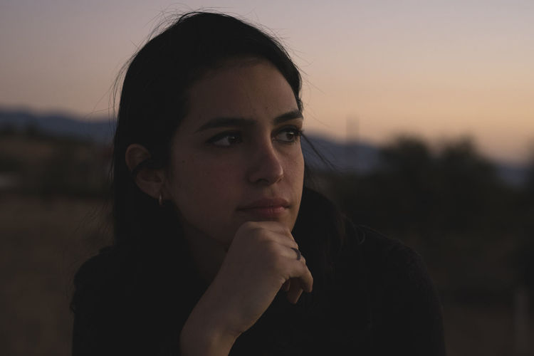 Close-up of woman looking away during sunset