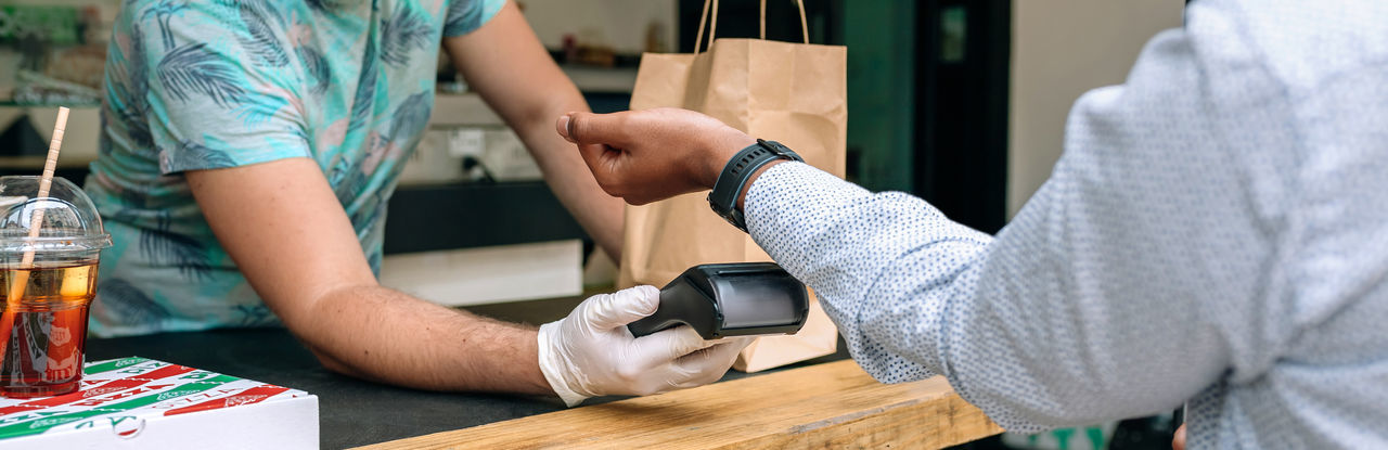 Man making contactless payment through smart watch at restaurant
