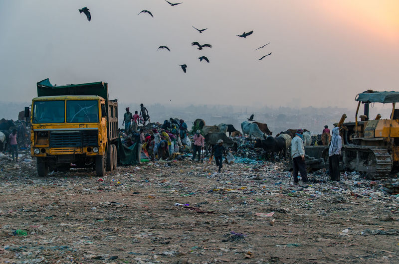 Group of people on garbage against the sky