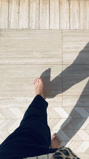 Low section of barefoot woman on tiled floor