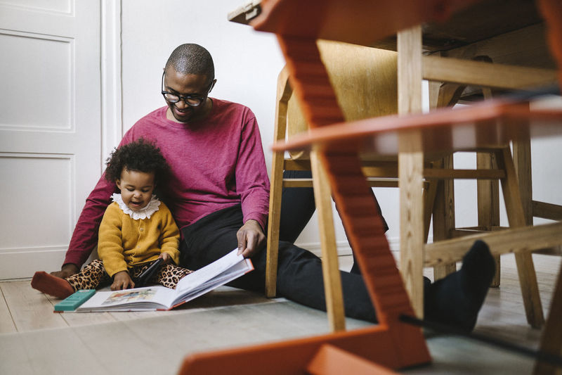 Father and daughter looking at illustrations in book