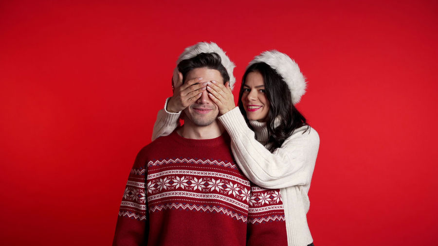 Portrait of a smiling couple against red background