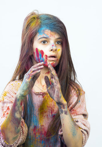 Face of a girl 7 years old in the colors of holi