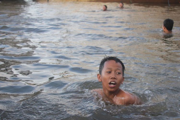 Portrait of happy boy swimming in water