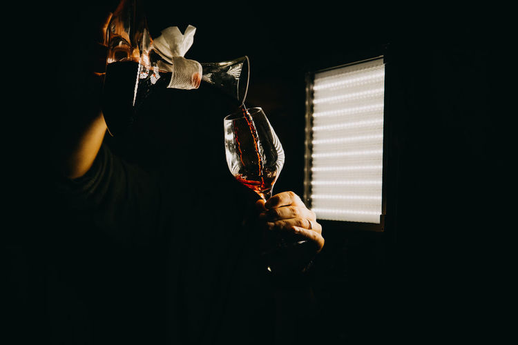 Woman pouring red wine in glass