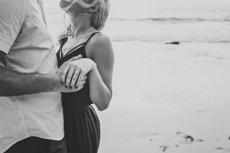 Midsection of romantic couple dancing at beach
