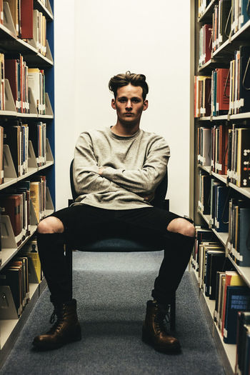 Portrait of young man sitting on book