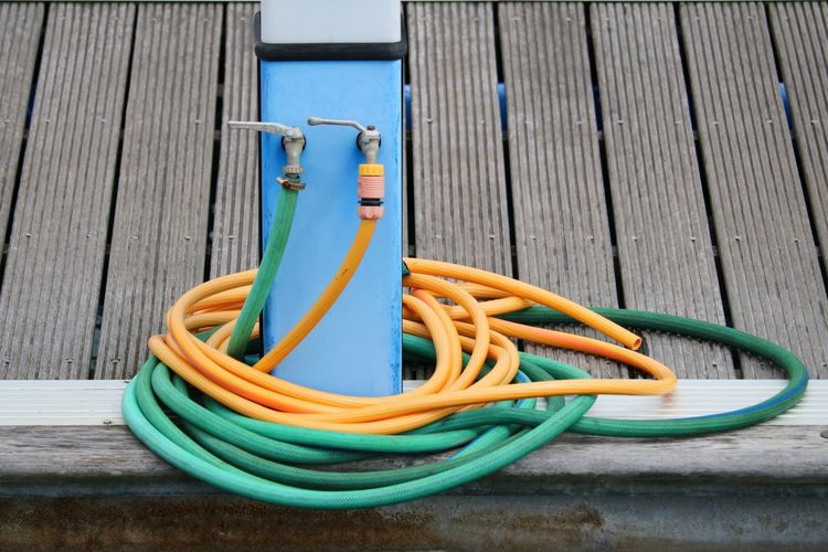 Close-up of yellow pipe on table against wall