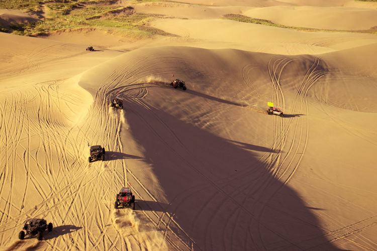 Dune buggy fleet riding along sand dunes.