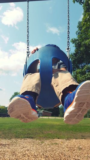 Low section of man on swing in playground