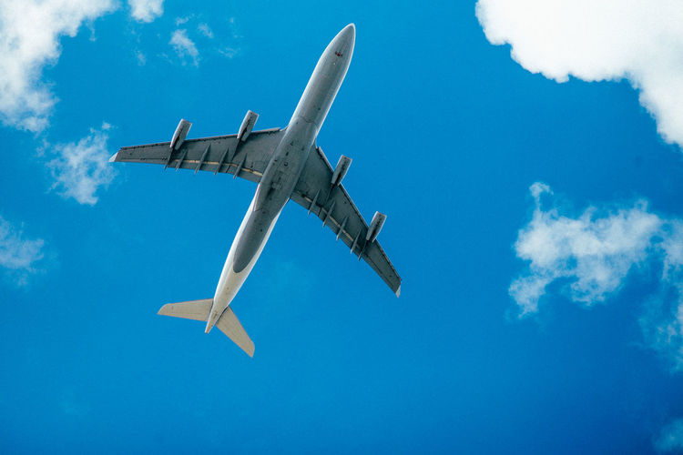 Low angle view of airplane flying against sky