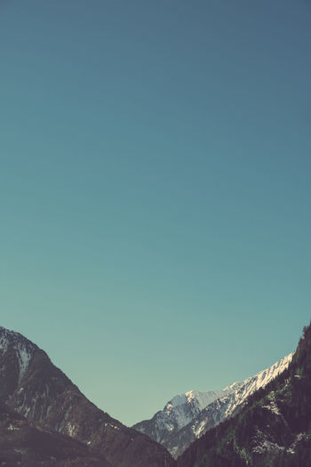 Low angle view of mountain against clear blue sky