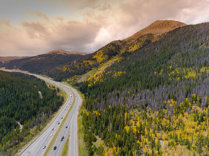 Scenic view of road by mountains against sky