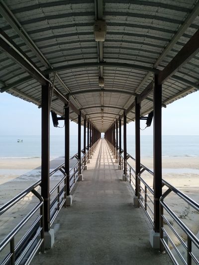 View of empty corridor along calm sea
