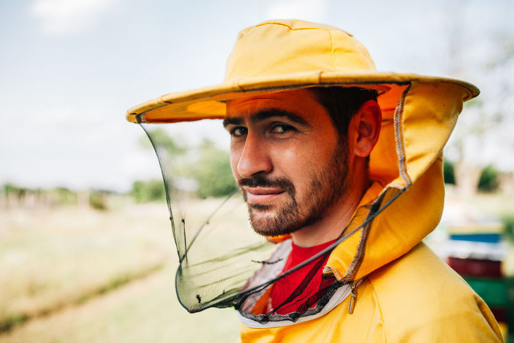 Close-up portrait of beekeeper standing on land