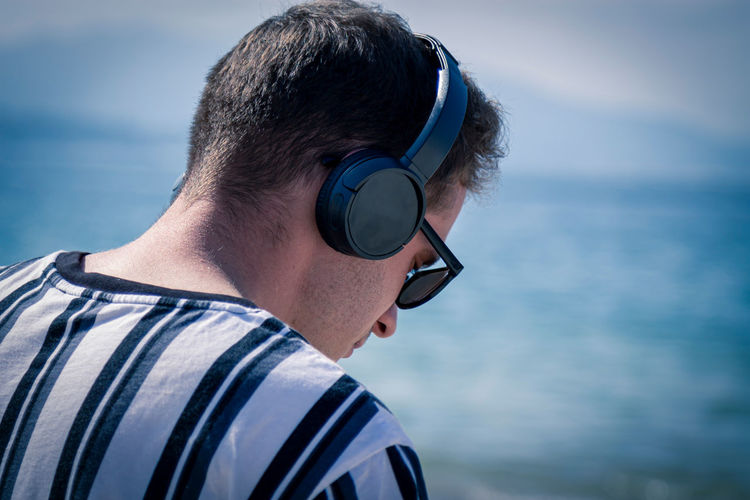 Relaxed man on the beach listening to music with his headphones