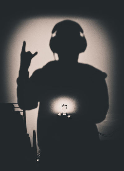 Silhouette man standing against wall