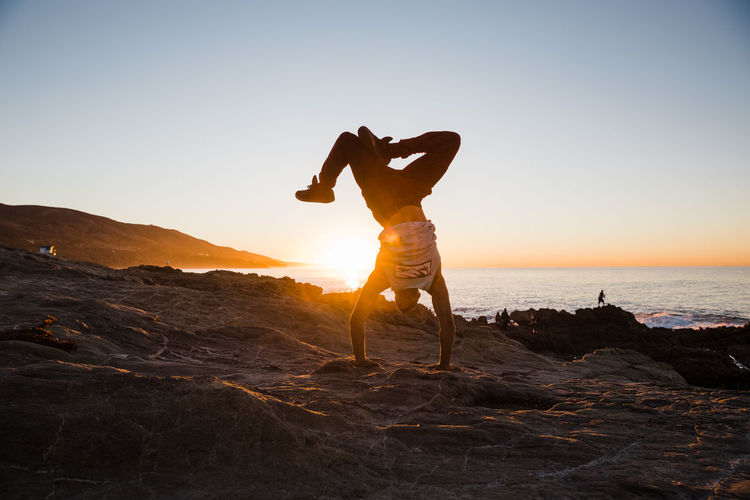 Hand stand on the beach at sunrise