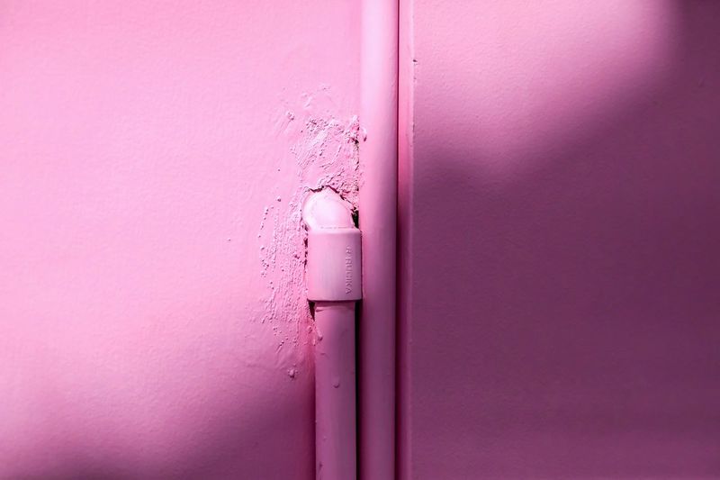 Close-up of pink pipe on wall
